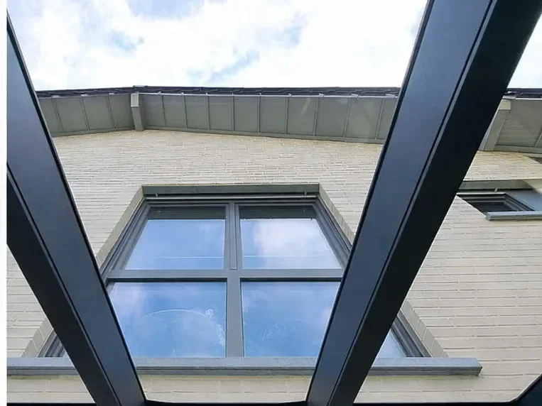 Dasselbe Vordach nachher: klares Glas mit freiem Blick auf Fassade und Himmel