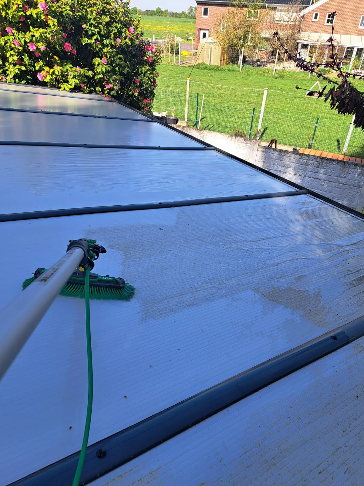 Terrassendach wird mit der Teleskop-Waschbürste und Reinwasser abgewaschen